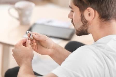 Hearing Loss and Health Problems | Soundwave Hearing Loss man looking at hearing aid