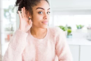 Woman suggests hearing amplification with her hands to the ear