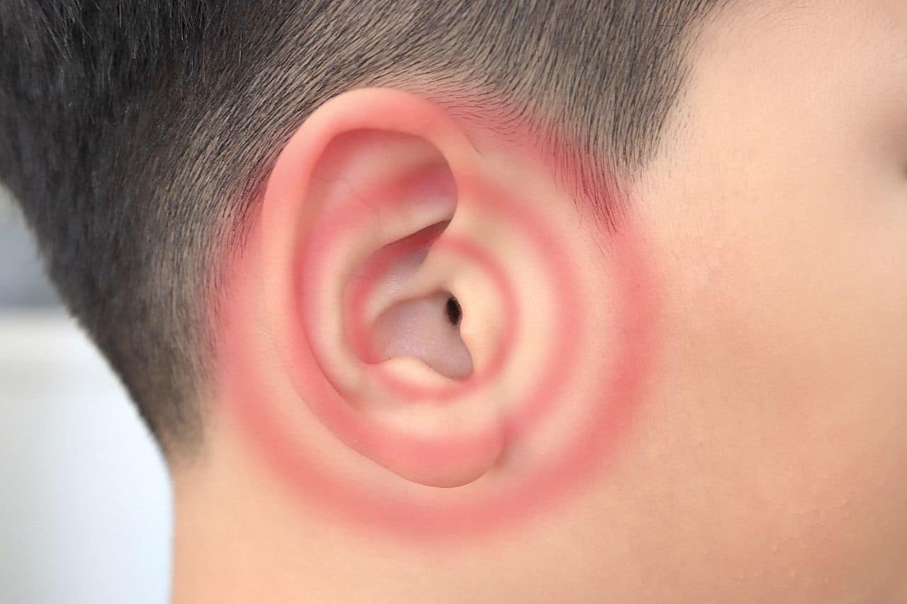 Young boy’s ear close up with red ripples signaling tinnitus